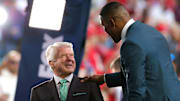 Jimmy Johnson, left, is greeted by Michael Strahan on the set of FOX's Super Bowl LIV coverage