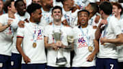 Christian Pulisic alzando el trofeo que acredita a los Estados Unidos como campeón de la CONCACAF Nations League.