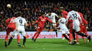 Valencia and Real Madrid players compete in the air