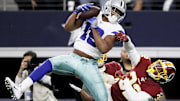 Cowboys receiver Amari Cooper, right, makes a catch over Redskins defensive back Jimmy Moreland.
