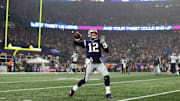 Tom Brady warms up on the sideline on Wild Card Weekend