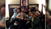 Blizzard employees posing with a framed portrait of Bill Cosby.