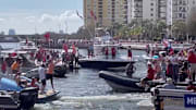 Tom Brady throws the Lombardi Trophy to another boat during Tampa Bay Buccaneers Super Bowl LV victory parade