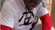 Dallas Cowboys pass rusher Aldon Smith is all smiles while signing his contract. 
