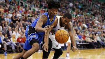 Dec 3, 2015; Salt Lake City, UT, USA; Orlando Magic guard Elfrid Payton (4) and Utah Jazz forward Derrick Favors (15) chase a loose ball in the first half at Vivint Smart Home Arena. Mandatory Credit: Jeff Swinger-USA TODAY Sports