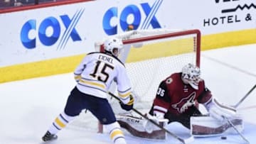Jan 18, 2016; Glendale, AZ, USA; Arizona Coyotes goalie Louis Domingue (35) makes a save on Buffalo Sabres center Jack Eichel (15) during the third period at Gila River Arena. Mandatory Credit: Matt Kartozian-USA TODAY Sports