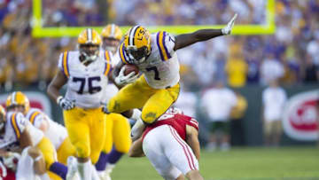 Sep 3, 2016; Green Bay, WI, USA; LSU Tigers running back Leonard Fournette (7) leaps over Wisconsin Badgers safety Leo Musso (19) during the fourth quarter at Lambeau Field. Mandatory Credit: Jeff Hanisch-USA TODAY Sports