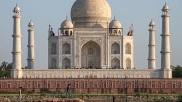 As the sun sets on 14 May 2019, tourists visit the Taj Mahal, one of the Seven Wonders of the World. The Taj Mahal is a white marble mausoleum built with nearly perfect geometric architecture on the banks of the Yamuna River in the city of Agra, India. Tourists visit the attraction year-round to marvel at its scenic gardens, its fine stone work, as well as the tombs of Mumtaz Mahal and Shah Jahan. Photos taken 14-15 May 2019. (Photo by Diego Cupolo/NurPhoto via Getty Images)