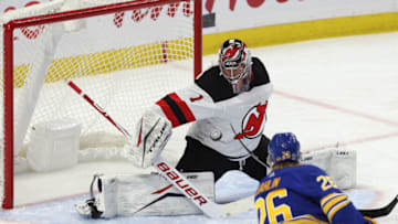 Jan 31, 2021; Buffalo, New York, USA; New Jersey Devils goaltender Eric Comrie (1) makes a save on Buffalo Sabres defenseman Rasmus Dahlin (26) during the second period at KeyBank Center. Mandatory Credit: Timothy T. Ludwig-USA TODAY Sports