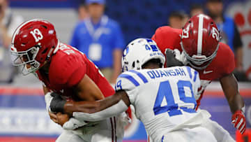 ATLANTA, GEORGIA - AUGUST 31: Tua Tagovailoa #13 of the Alabama Crimson Tide nearly has the ball stripped by Koby Quansah #49 of the Duke Blue Devils in the first half at Mercedes-Benz Stadium on August 31, 2019 in Atlanta, Georgia. (Photo by Kevin C. Cox/Getty Images)