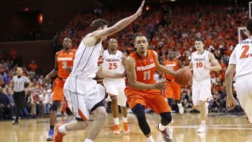 Mar 1, 2014; Charlottesville, VA, USA; Syracuse Orange guard Tyler Ennis (11) dribbles the ball as Virginia Cavaliers guard Joe Harris (12) defends in the first half at John Paul Jones Arena. Mandatory Credit: Geoff Burke-USA TODAY Sports