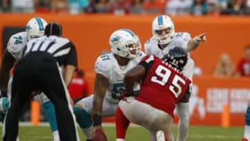 Sep 22, 2013; Miami Gardens, FL, USA; Miami Dolphins quarterback Ryan Tannehill (17) and center Mike Pouncey (51) at the line of scrimage as Atlanta Falcons defensive end Jonathan Babineaux (95) looks on in the fourth quarter at Sun Life Stadium. Miami won 27-23. Mandatory Credit: Robert Mayer-USA TODAY Sports