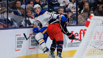 Sep 28, 2022; Columbus, Ohio, USA; Columbus Blue Jackets forward Carson Meyer (right) checks Buffalo Sabres center Peyton Krebs (19) along the boards in the third period at Nationwide Arena. Mandatory Credit: Aaron Doster-USA TODAY Sports