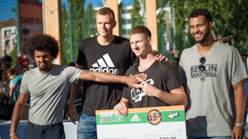 14 July 2018, Germany, Berlin: Dilim Onyia (l-r), presenter; Kristaps Porzingis, power forward with the New York Knicks; Vadim Poddubchenko, winner of the slamdunk contest; and Badu Buck, player with ALBA Berlin, pose for a photo after a streetball tournament at the Friedrich-Ludwig-Jahn-Sportpark. Photo: Gregor Fischer/dpa (Photo by Gregor Fischer/picture alliance via Getty Images)