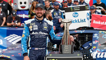 CHARLOTTE, NC - OCTOBER 08: Martin Truex Jr., driver of the #78 Auto-Owners Insurance Toyota, poses with the trophy in Victory Lane after winning the Monster Energy NASCAR Cup Series Bank of America 500 at Charlotte Motor Speedway on October 8, 2017 in Charlotte, North Carolina. (Photo by Brian Lawdermilk/Getty Images)