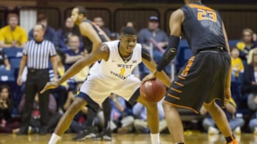 Jan 9, 2016; Morgantown, WV, USA; West Virginia Mountaineers forward Jonathan Holton (1) guards Oklahoma State Cowboys guard Leyton Hammonds (23) during the first half at the WVU Coliseum. Mandatory Credit: Ben Queen-USA TODAY Sports