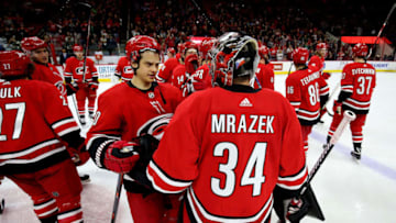 RALEIGH, NC - MARCH 23: Petr Mrazek #34 of the Carolina Hurricanes is congratulated by teammate Sebastian Aho #20 following a victory over the Minnesota Wild during an NHL game on March 23, 2019 at PNC Arena in Raleigh, North Carolina. (Photo by Gregg Forwerck/NHLI via Getty Images)