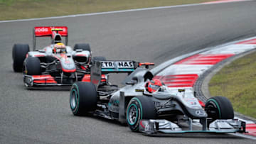 SHANGHAI, CHINA - APRIL 18: Michael Schumacher (red helmet) of Germany and Mercedes GP and Lewis Hamilton (yellow helmet) of Great Britain and McLaren Mercedes fight for position as they drive during the Chinese Formula One Grand Prix at the Shanghai International Circuit on April 18, 2010 in Shanghai, China. (Photo by Clive Mason/Getty Images)