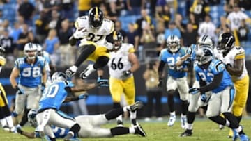 Sep 21, 2014; Charlotte, NC, USA; Pittsburgh Steelers running back LeGarrette Blount (27) carries the ball as Carolina Panthers cornerback Antoine Cason (20), defensive tackle Star Lotulelei (98), and cornerback Melvin White (23) defend in the fourth quarter. The Steelers defeated the Panthers 37-19 at Bank of America Stadium. Mandatory Credit: Bob Donnan-USA TODAY Sports