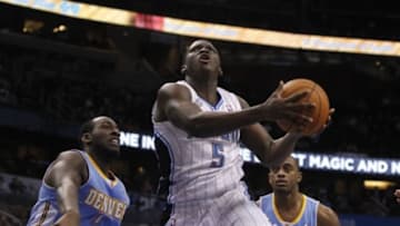Mar 12, 2014; Orlando, FL, USA; Orlando Magic guard Victor Oladipo (5) drives to the basket as Denver Nuggets center J.J. Hickson (7) and forward Darrell Arthur (00) defend during the second half at Amway Center. Denver Nuggets defeated the Orlando Magic 120-112. Mandatory Credit: Kim Klement-USA TODAY Sports