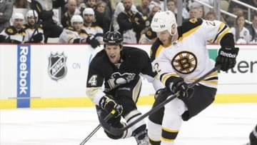 Jun 1, 2013; Pittsburgh, PA, USA; Pittsburgh Penguins defenseman Mark Eaton (4) chases the puck alongside Boston Bruins right wing Shawn Thornton (22) during the second period in game one of the Eastern Conference finals of the 2013 Stanley Cup Playoffs at the CONSOL Energy Center. Mandatory Credit: Charles LeClaire-USA TODAY Sports