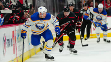Dec 2, 2023; Raleigh, North Carolina, USA; Buffalo Sabres left wing Brandon Biro (15) skates with the puck away from Carolina Hurricanes defenseman Dmitry Orlov (7) during the second period PNC Arena. Mandatory Credit: James Guillory-USA TODAY Sports