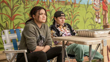 Reservation Dogs -- “NDN Clinic” - Episode 102 -- A new crew threatens the Reservation Dogs while they try and make some money selling meat pies outside the local IHS Clinic. Written by Sterlin Harjo; Directed by Sydney Freeland. Elora (Devery Jacobs) and Willie (Paulina Alexis), shown. (Photo Courtesy of FX on Hulu)