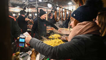KRAKOW, POLAND - DECEMBER 03: Visitors buy food and visit stands in the Christmas Markets at Krakow's UNESCO Listed Main Square in Krakow, Poland on December 03, 2022. This year, Krakow's Christmas Market is among the most interesting European Christmas fairs, which "The Times" encourages to visit this year. (Photo by Omar Marques/Anadolu Agency via Getty Images)