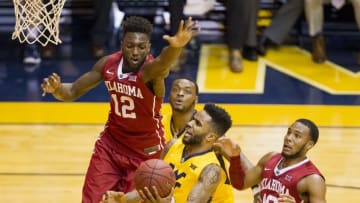 Feb 20, 2016; Morgantown, WV, USA; West Virginia Mountaineers guard Tarik Phillip (12) shoots the ball as Oklahoma Sooners forward Khadeem Lattin (12) defends during the second half at the WVU Coliseum. Mandatory Credit: Ben Queen-USA TODAY Sports