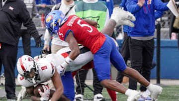 Nov 11, 2023; Lawrence, Kansas, USA; Kansas Jayhawks safety O.J. Burroughs (5) tackles Texas Tech Red Raiders wide receiver Jerand Bradley (9) during the second half at David Booth Kansas Memorial Stadium. Mandatory Credit: Denny Medley-USA TODAY Sports