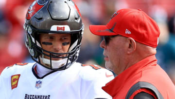 TAMPA, FLORIDA - JANUARY 16: Tom Brady #12 of the Tampa Bay Buccaneers talks with head coach Bruce Arians prior to the NFC Wild Card Playoff game against the Philadelphia Eagles at Raymond James Stadium on January 16, 2022 in Tampa, Florida. (Photo by Mike Ehrmann/Getty Images)