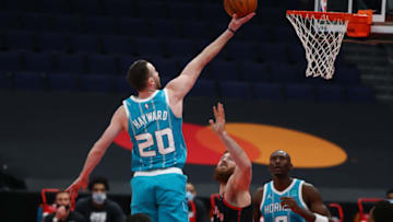 Jan 16, 2021; Tampa, Florida, USA; Charlotte Hornets forward Gordon Hayward (20) makes a layup over Toronto Raptors center Aron Baynes (46) during the first quarter at Amalie Arena. Mandatory Credit: Kim Klement-USA TODAY Sports