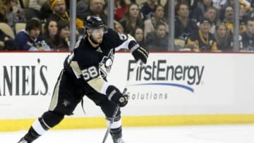 Jan 18, 2015; Pittsburgh, PA, USA; Pittsburgh Penguins defenseman Kris Letang (58) moves the puck against the New York Rangers during the third period at the CONSOL Energy Center. The Rangers won 5-2. Mandatory Credit: Charles LeClaire-USA TODAY Sports
