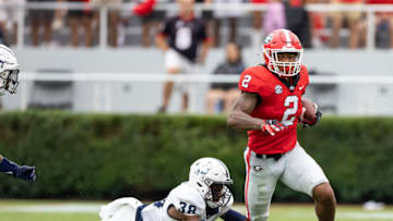 ATHENS, GA - SEPTEMBER 10: Kendall Milton #2 of the Georgia Bulldogs avoids a tackle by Fred Flavors #38 of the Samford Bulldogs during a game between Samford Bulldogs and Georgia Bulldogs at Sanford Stadium on September 10, 2022 in Athens, Georgia. (Photo by Steve Limentani/ISI Photos/Getty Images)