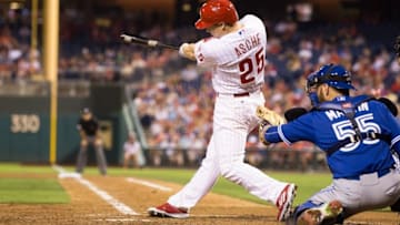 Aug 18, 2015; Philadelphia, PA, USA; Philadelphia Phillies left fielder Cody Asche (25) hits an RBI single during the fourth inning against the Toronto Blue Jays at Citizens Bank Park. Mandatory Credit: Bill Streicher-USA TODAY Sports