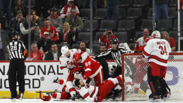 Mar 10, 2020; Detroit, Michigan, USA; Detroit Red Wings left wing Tyler Bertuzzi (59) throws Carolina Hurricanes center Vincent Trocheck (16) to the ground as he is being held by left wing Warren Foegele (13) during the third period at Little Caesars Arena. Mandatory Credit: Raj Mehta-USA TODAY Sports