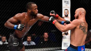 SINGAPORE - JUNE 23: (L-R) Leon Edwards of Jamaica punches Donald Cerrone in their welterweight bout during the UFC Fight Night event at the Singapore Indoor Stadium on June 23, 2018 in Singapore. (Photo by Jeff Bottari/Zuffa LLC/Zuffa LLC via Getty Images)
