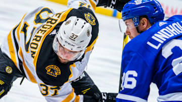 TORONTO, ON - JANUARY 12: Patrice Bergeron #37 of the Boston Bruins takes a face off agains Par Lindholm #26 of the Toronto Maple Leafs during the second period at the Scotiabank Arena on January 12, 2019 in Toronto, Ontario, Canada. (Photo by Mark Blinch/NHLI via Getty Images)