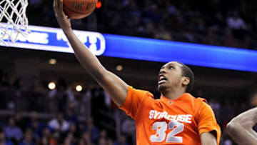 Syracuse's Kris Joseph goes up with a shot as he splits the defense of Seton Hall's Keon Lawrence, left, and Jeff Robinson, right, during the second half of an NCAA college basketball game Tuesday, Dec. 29, 2009, in Newark, N.J. Syracuse beat Seton Hall 80-73. (AP Photo/Bill Kostroun)