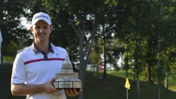 Jun 29, 2014; Bethesda, MD, USA; Justin Rose holds the Quicken Loans National trophy up after defeating Shawn Stephani in a one-hole playoff on the 18th green after the Quicken Loans National golf tournament at Congressional Country Club - Blue Course. Mandatory Credit: Tommy Gilligan-USA TODAY Sports