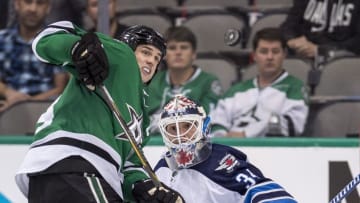 Oct 25, 2016; Dallas, TX, USA; Dallas Stars left wing Jamie Benn (14) and Winnipeg Jets goalie Michael Hutchinson (34) track the puck in midair during the third period at the American Airlines Center. The Stars defeat the Jets 3-2. Mandatory Credit: Jerome Miron-USA TODAY Sports