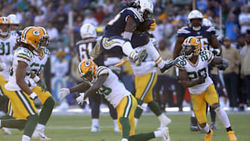 CARSON, CALIFORNIA - NOVEMBER 03: Melvin Gordon #25 of the Los Angeles Chargers leaps over Chandon Sullivan #39 of the Green Bay Packers as Tony Brown #28 of the Green Bay Packers defends during the second half of a game at Dignity Health Sports Park on November 03, 2019 in Carson, California. (Photo by Sean M. Haffey/Getty Images)