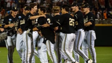 Jun 21, 2014; Omaha, NE, USA; Teammate mob Vanderbilt Commodores infielder Tyler Campbell (2) celebrates after driving in the winning run against the Texas Longhorns during game thirteen of the 2014 College World Series at TD Ameritrade Park Omaha. Vanderbilt defeated Texas 4-3 in ten innings. Mandatory Credit: Steven Branscombe-USA TODAY Sports