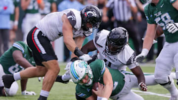 Tulane Green Wave quarterback Kai Horton is sacked by Cincinnati Bearcats defensive lineman Myjai Sanders. USA Today.
