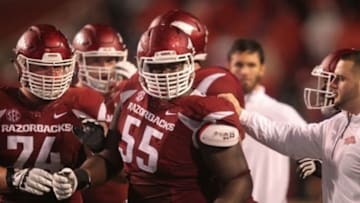 Nov 22, 2014; Fayetteville, AR, USA; Arkansas Razorbacks offensive guard Brey Cook (74) and staff hold back offensive lineman Denver Kirkland (55) after a play against the Ole Miss Rebels at Donald W. Reynolds Razorback Stadium. Arkansas defeated Mississippi 30-0. Mandatory Credit: Nelson Chenault-USA TODAY Sports