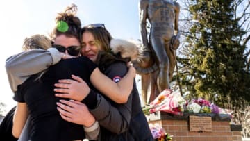(Left to right) Michigan State University junior Tori VanSlambrouck of Kalamazoo is hugged by senior Alix Matzke of Cadillac and junior Emily Finkbeiner of Saline after they left flowers at the base of the Sparty statue following an active shooting incident on the Michigan State University campus in East Lansing on Tuesday, February 14, 2023, that left three people dead and multiple injured.