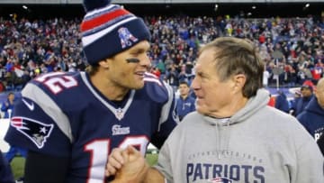 Dec 14, 2014; Foxborough, MA, USA; New England Patriots quarterback Tom Brady (12) celebrates with head coach Bill Belichick (R) after clinching the AFC East title with a 41-13 win over the Miami Dolphins at Gillette Stadium. Mandatory Credit: Winslow Townson-USA TODAY Sports