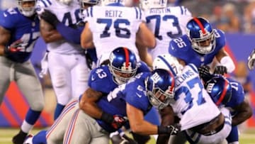 Aug 18, 2013; East Rutherford, NJ, USA; Indianapolis Colts running back Kerwynn Williams (37) is stopped by New York Giants linebacker Jake Muasau (43) and defensive end Matt Broha (54) and safety Will Hill (25) and defensive end Adewale Ojomo (71) during the fourth quarter of a preseason game at MetLife Stadium. The colts defeated the Giants 20-12. Mandatory Credit: Brad Penner-USA TODAY Sports