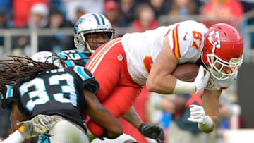 Travis Kelce #87 of the Kansas City Chiefs dives between Tre Boston #33 and Leonard Johnson #23 of the Carolina Panthers (Photo by Grant Halverson/Getty Images)