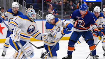 Mar 7, 2023; Elmont, New York, USA; Buffalo Sabres defenseman Ilya Lyubushkin (46) stops the puck with his gloves in front of New York Islanders center Casey Cizikas (53) and goaltender Ukko-Pekka Luukkonen (1) during the second period at UBS Arena. Mandatory Credit: Dennis Schneidler-USA TODAY Sports